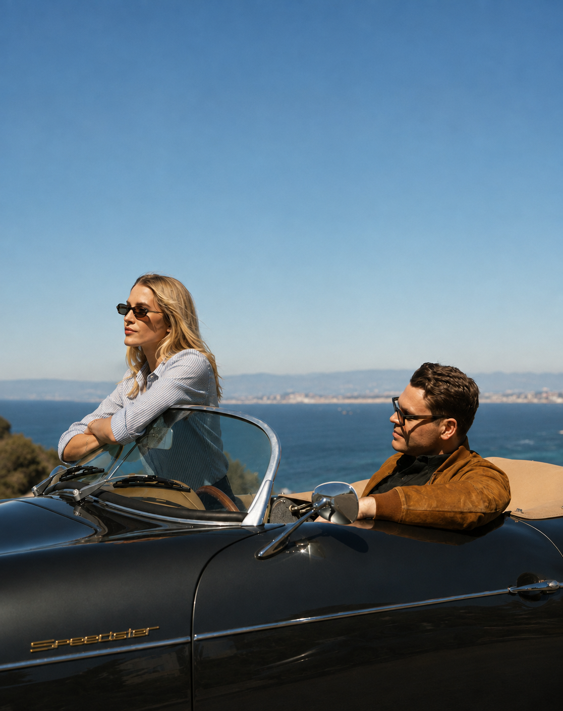Couple in a vintage convertible parked above the sea
